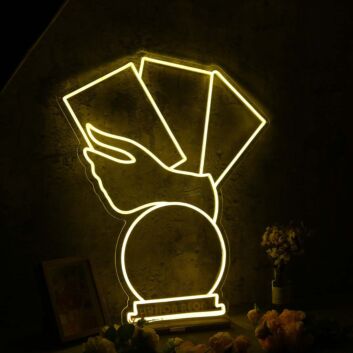 Hand Holding Fanned Cards Above a Circle LED Neon Sign