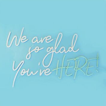 We Are So Glad Youre Here Neon Sign creates a welcoming atmosphere