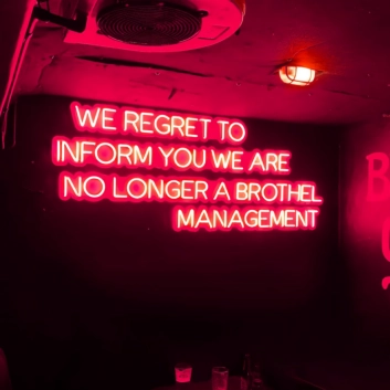 We Regret to Inform You We Are No Longer a Brothel Management Neon Sign: Changing Times in Neon