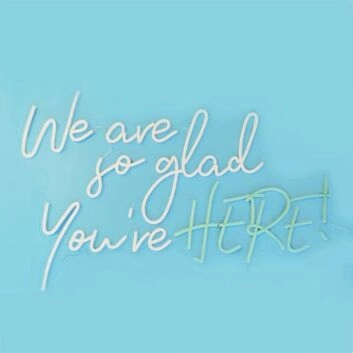 We Are So Glad Youre Here Neon Sign creates a welcoming atmosphere