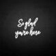 'So glad you're here' neon sign