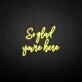 'So glad you're here' neon sign