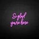 'So glad you're here' neon sign