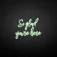 'So glad you're here' neon sign