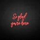 'So glad you're here' neon sign